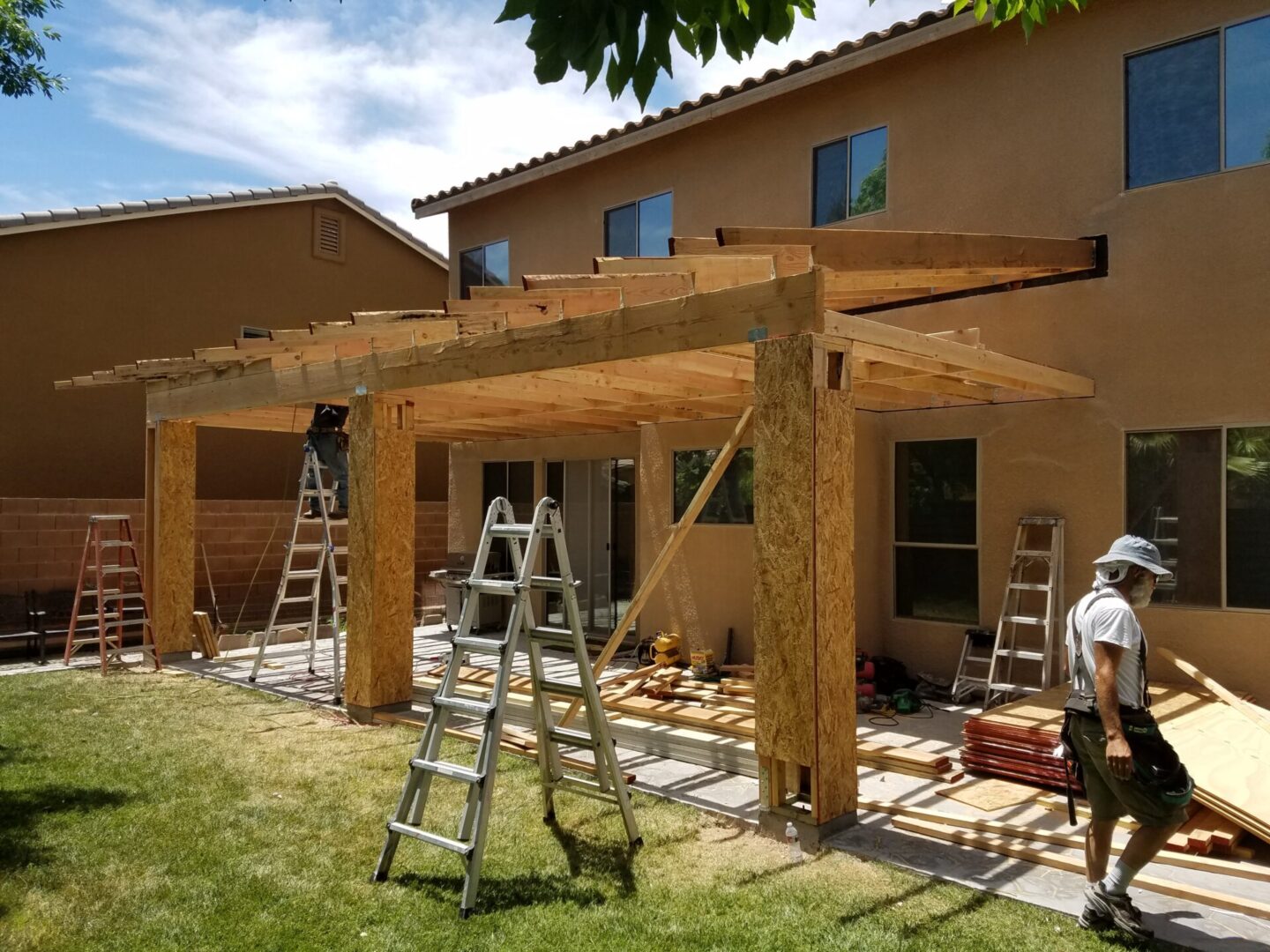 Construction of a wooden pergola in a backyard.