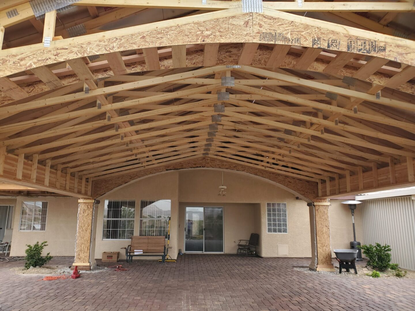 A spacious wooden pergola with a tiled roof over a patio area.