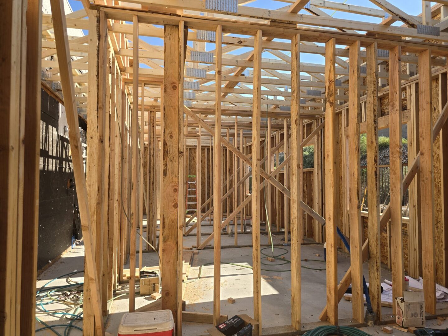 Wooden framing of a house under construction inside a garage.